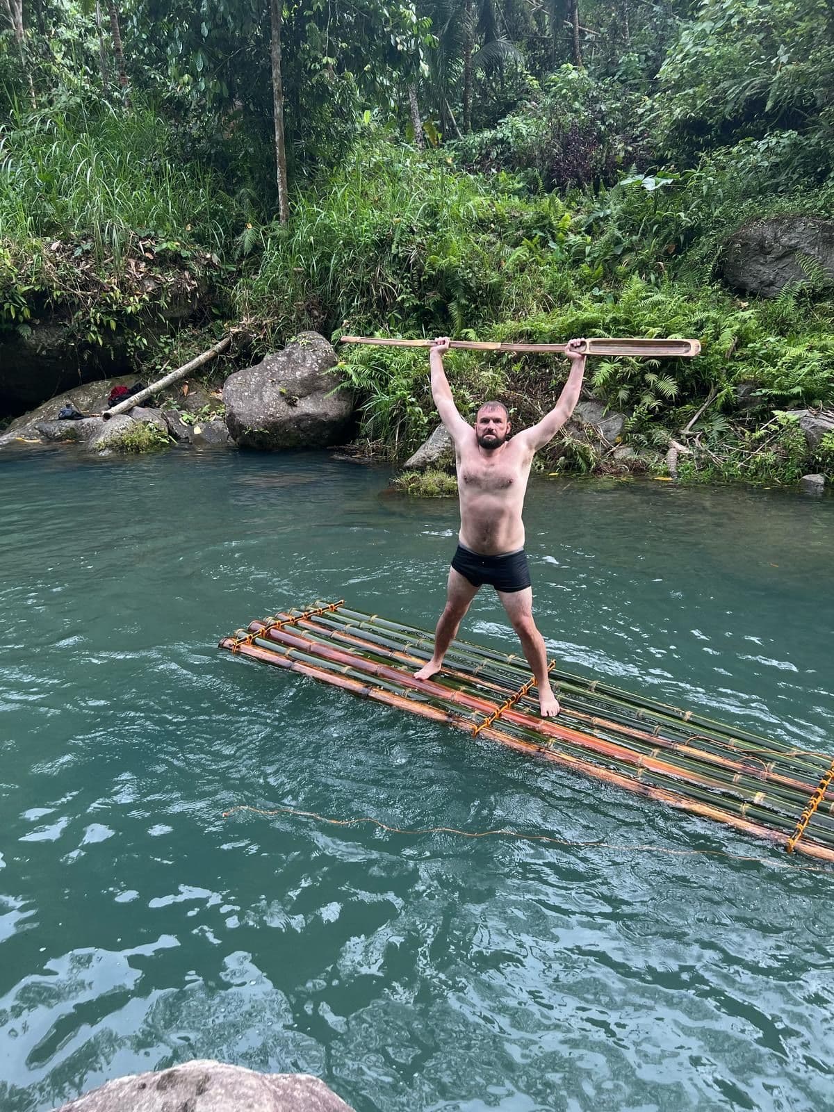 Wildman Nakamoto standing on bamboo raft